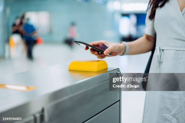 cropped shot of young asian woman checking in at subway station using contactless payment for subway ticket via smartphone - train ticket stock pictures, royalty-free photos & images