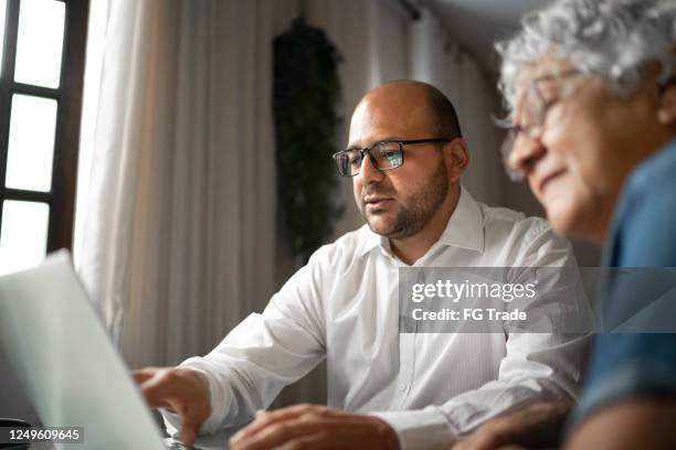 asesor ayudando a una mujer de la tercera edad en casa (o madre e hijo) - accesorio financiero fotografías e imágenes de stock