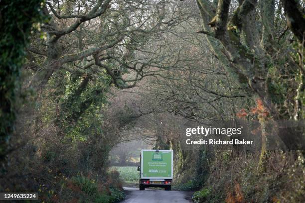 Waitrose supermarket deliveries van makes its way through a narrow lane in Mawnan Smith, on 19th March 2023, in Mawnan Smith, Cornwall, England.