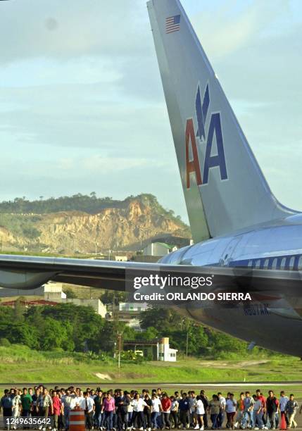 Hondurans deported from the United States, walk by the runway of the Tegucigalpa airport, 12 July 2002. AFP PHOTO/Orlando SIERRA Un total de 105...