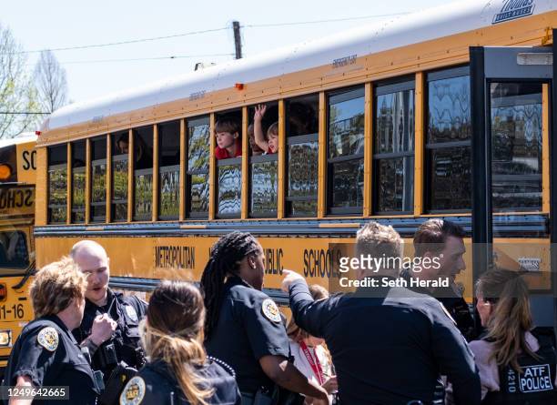 School buses with children arrive at Woodmont Baptist Church to be reunited with their families after a mass shooting at The Covenant School on March...
