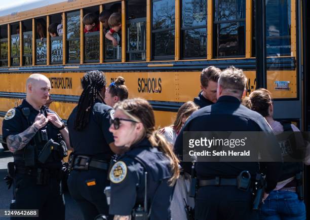School buses with children arrive at Woodmont Baptist Church to be reunited with their families after a mass shooting at The Covenant School on March...