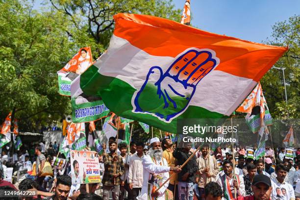 Supporter of Indian National Congress waves a flag during a protest against the disqualification from the Indian Parliament of India's main...