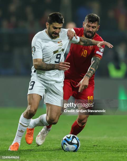 Aleksandar Mitrovic of Serbia in action against Aleksandar Scekic of Montenegro during the UEFA EURO 2024 qualifying round group B match between...