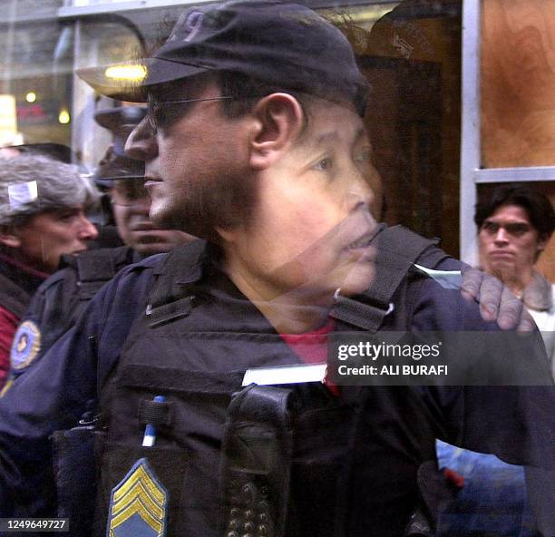 The reflection of a Federal policeman can be seen through the window of car where an asian woman awaits verification of her immigration status in the...