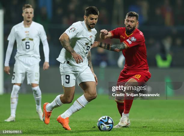 Aleksandar Mitrovic of Serbia in action against Aleksandar Scekic of Montenegro during the UEFA EURO 2024 qualifying round group B match between...