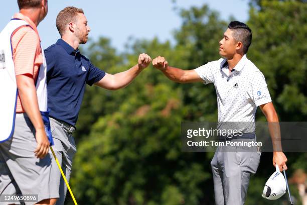 Daniel Berger of the United States bumps fists with Collin Morikawa of the United States on the 17th green after defeating him during a playoff in...