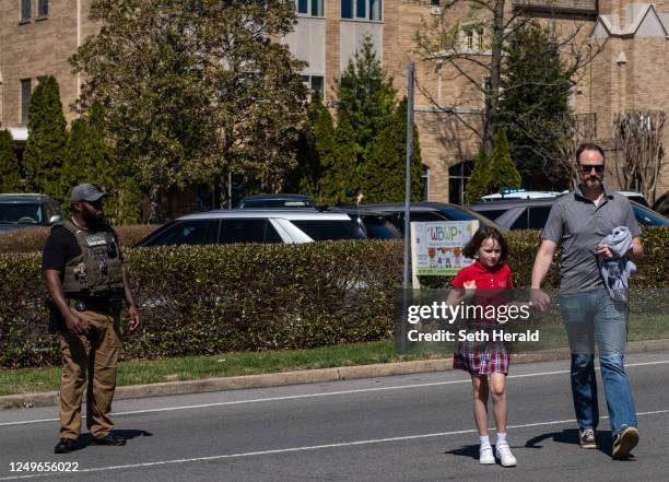 Parent walks with their child from Woodmont Baptist Church where children were reunited with their families after a mass shooting at The Covenant...