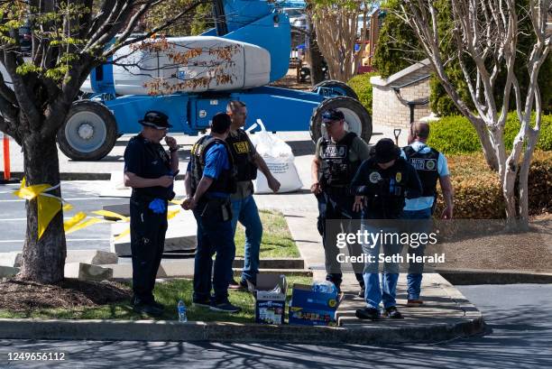 Law enforcement officers stand outside of Woodmont Baptist Church while waiting for children to be reunited with their families after a mass shooting...