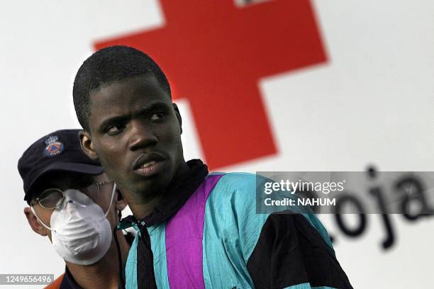 An illegal immigrant stands by a Red Cross tent with 43 others at Puerto de Los Cristianos on the island of Tenerife after being picked up by coast...