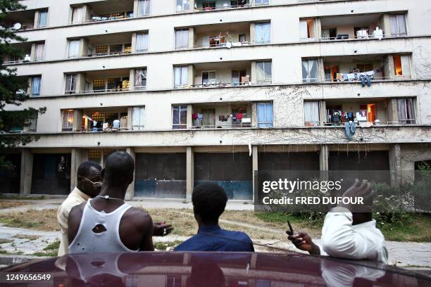 Group of people chat in front of a building housing a giant squat in Cachan, Southern Paris Suburbs, 31 July 2006. For over a period of three years,...