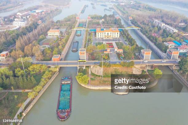 Cargo ships loaded with fertilizers, building materials and thermal coal pass through the Suqian lock on the Beijing-Hangzhou Grand Canal in Suqian,...
