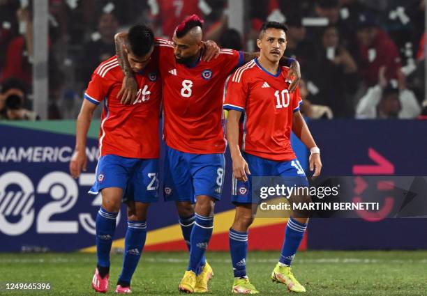 Chile's forward Alexis Sanchez celebrates with teammates midfielder Arturo Vidal and forward Alexander Aravena after scoring against Paraguay during...