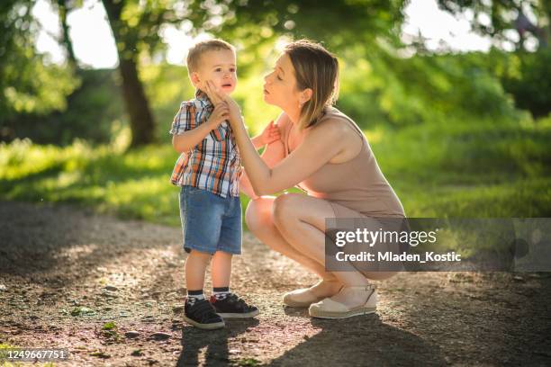 mother consoling crying child because his leg is hurt during their walk through the forest, after coronavirus, covid-19 quarantine - toddler crying stock pictures, royalty-free photos & images