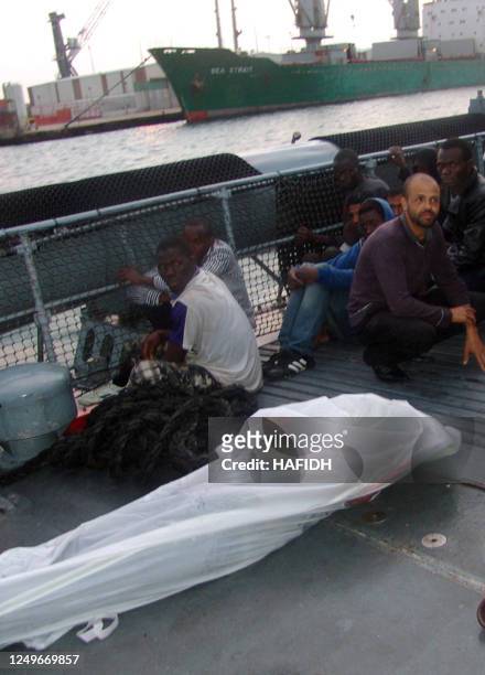 The body of a drowned would-be migrant lies amongst African migrants after being rescued after fleeing Libya by Tunisian coastguard near off the...