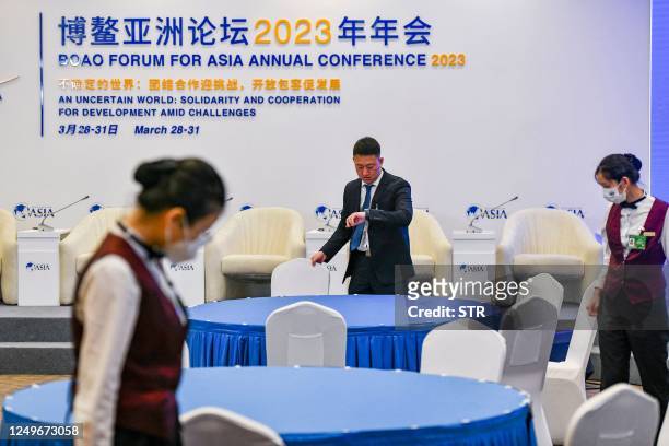 This photo taken on March 27, 2023 shows staff members preparing the stage of a main hall ahead of the Boao Forum for Asia in Boao, south China's...