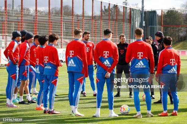 Newly-appointed Bayern Munich coach Thomas Tuchel talks with his players as he oversees his first training session at German first division...