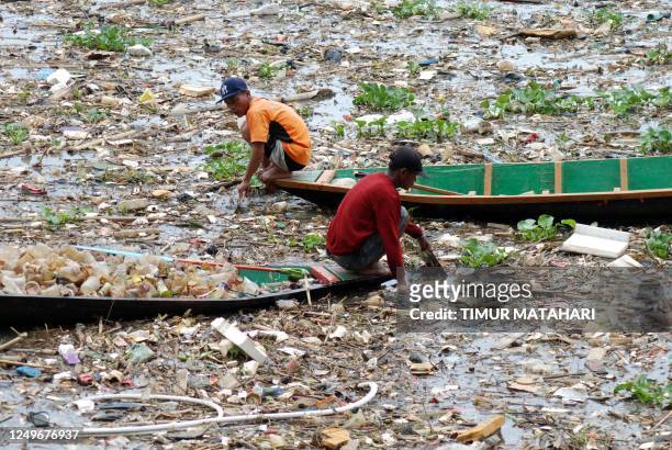 Two scavengers collect plastics in the Citarum river in Bandung, West Java on March 28, 2023.