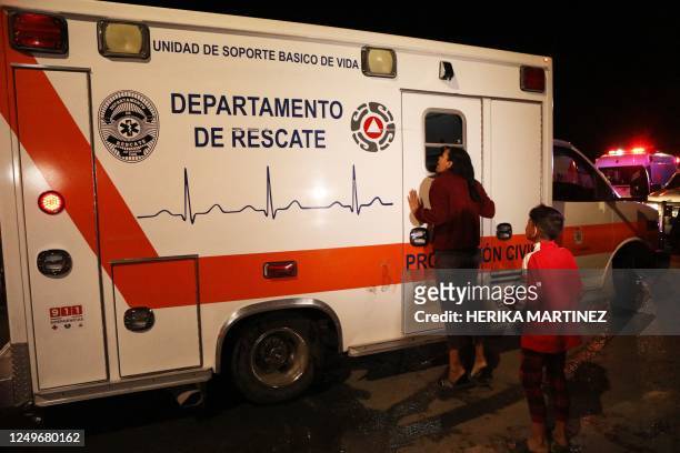 Viangly, a Venezuelan migrant, cries next to an ambulance in which her husband, who was injured in a fire, is being transported following a fire at...