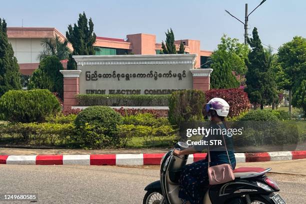 Woman rides her motorcycle in front of the Union Election Commission in Nay Pyi Thaw on March 28, 2023.