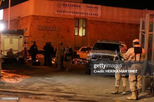 Members of the National Guard stand during a rescue for migrants from an immigration station in Ciudad Juarez, Chihuahua state on March 28 where at...