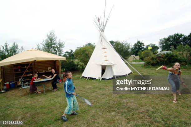 Des enfants jouent autour du tipi du gîte écologique, le 04 août 2006 à Bricqueville-sur-mer. Au fond , une cuisine en plein air a été construite. Le...
