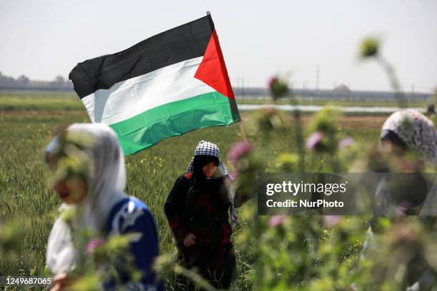 Palestinian woman holds a national flag during an event marking the 47th anniversary of Land Day, east of Gaza City by the border with Israel on...