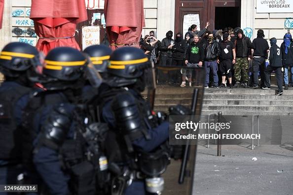 Anti Riot Fair Anti-riot police stand behind their shields in front of protesters ...
