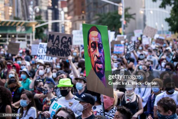Protester holds a sign with a portrait painting of George Floyd in the middle of the crowd that gathered at Columbus Circle. This was part of the...