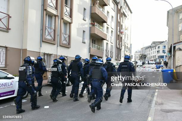Anti-riot police officers patrol in a street following clashes with protesters on the sideline of a demonstration after the government pushed a...