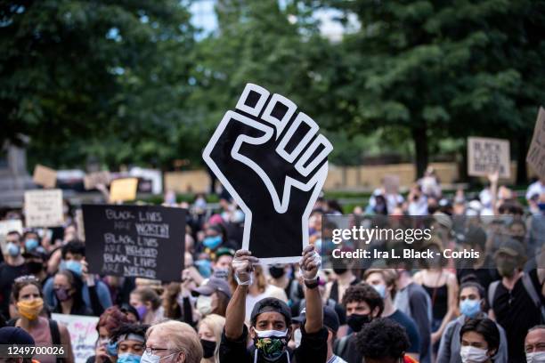 Protester wearing a mask holds a large black power raised fist in the middle of the crowd that gathered at Columbus Circle. This was part of the...