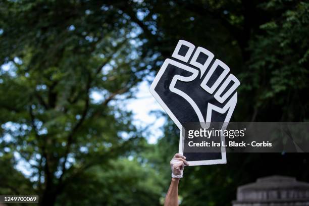 Protester wearing a mask holds a large black power raised fist in the middle of the crowd that gathered at Columbus Circle. This was part of the...