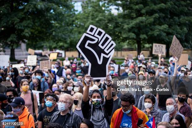 Protester wearing a mask holds a large black power raised fist in the middle of the crowd that gathered at Columbus Circle. This was part of the...