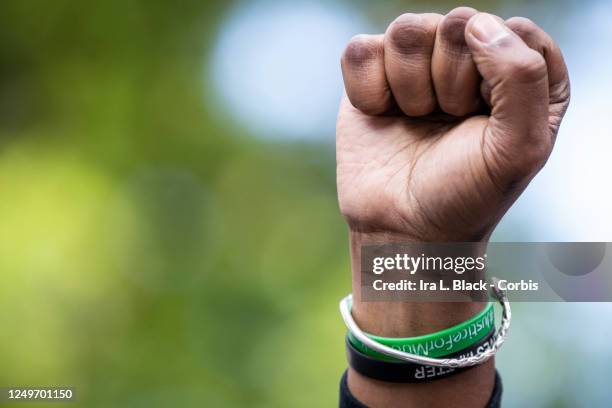 Hawk Newsome, Chairperson of the Black Lives Matter Greater NY holds up a raised fist as he listens to Chivona Renee Newsome, the Co-Founder of Black...