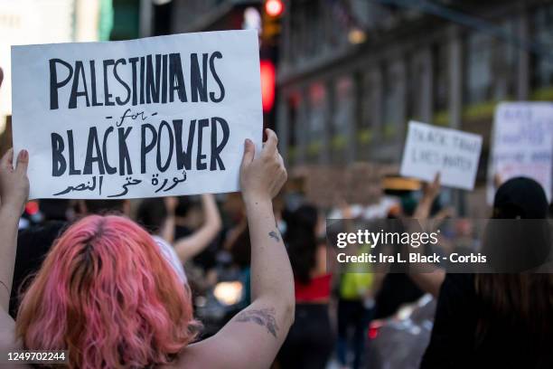 Protester holds a sign that reads, "Palestinians for Black Power" as they march through the streets of New York City. This was part of the Warriors...