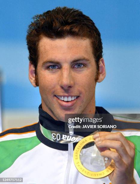 Australia's Grant Hackett displays his gold medal on the podium of the men's 800m freestyle event, 25 July 2003 in Barcelona, at the 10th FINA...