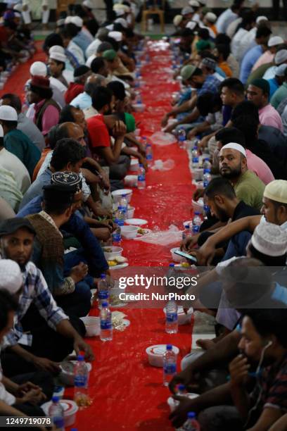 Muslims sit together before breaking their fast during the Holy month of Ramadan at Baitul Mukarram National Mosque in Dhaka, Bangladesh on March 28,...