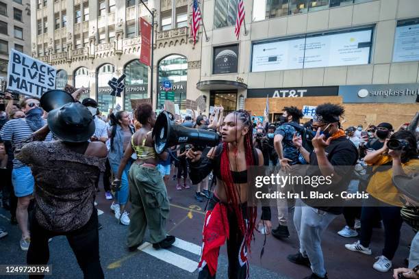 Livia Johnson, an organization leader for Warriors in the Garden screams into the megaphone to get the hundreds of protesters that marched from Trump...