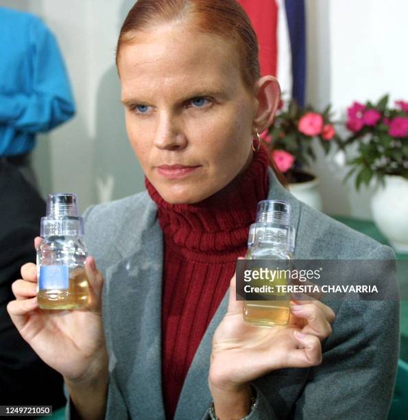 The Costa Rican swimmer, Claudia Poll, demonstrates two urine viles she will use in her defense 06 June 2002, during a press conference in San Jose,...