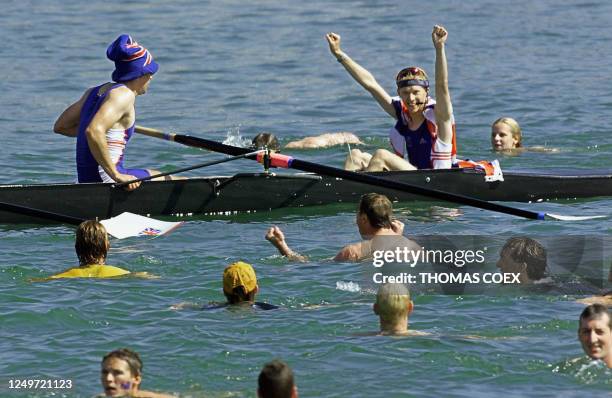 British supporters jump in Pernith Lake to celebrate Britain's Olympic gold medal win in the men's eight rowing competition, 24 September 2000 with...