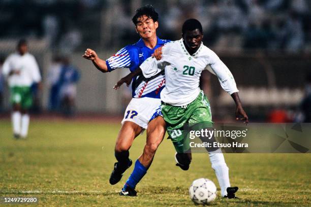 Hamzah Idris of Saudi Arabia and Hajime Moriyasu of Japan compete for the ball during the FIFA World Cup Asian Qualifier final round match between...