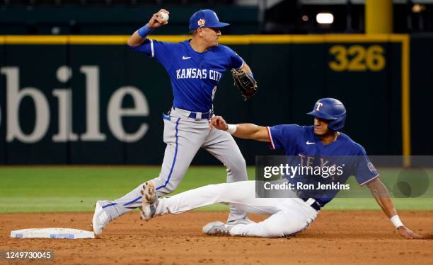 Nicky Lopez of the Kansas City Royals throws to first base to complete a double play as Bubba Thompson of the Texas Rangers slides into second base...