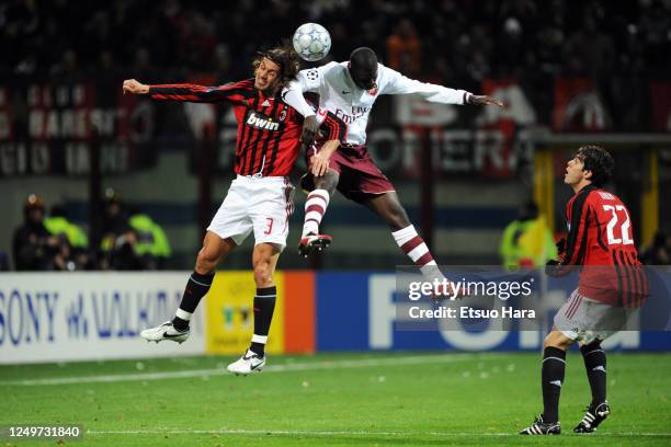 Paolo Maldini of AC Milan and Emmanuel Eboue of Arsenal compete for the ball during the UEFA Champions League Round of 16 second leg match between AC...
