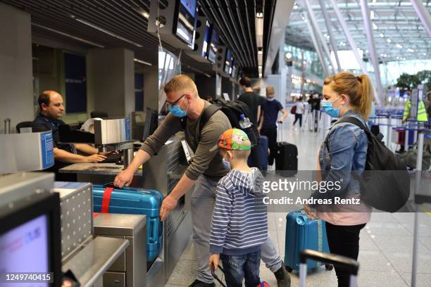 Tourists wait to check in for TUIfly flight X3 2312, the first package tour flight to Mallorca since March, at Dusseldorf Airport during the...
