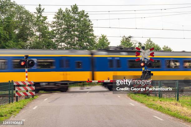 train passing by a railway crossing - train crossing stock pictures, royalty-free photos & images