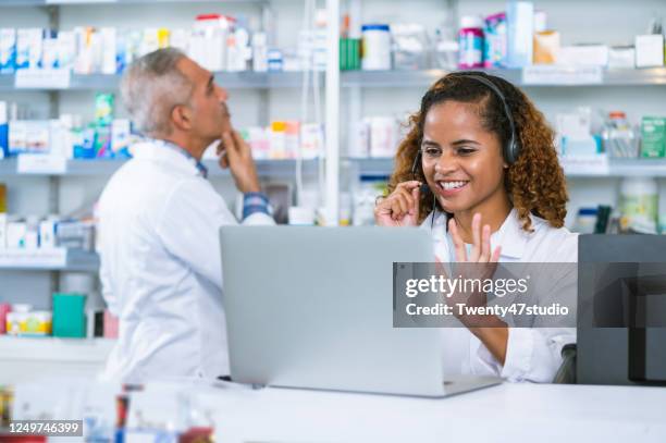 two pharmacists working at pharmacy get an order and support q&a on video call on laptop - online q and a stock pictures, royalty-free photos & images