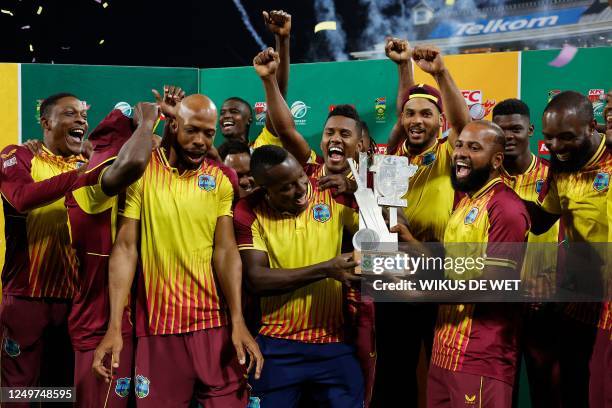 West Indies' players celebrate with the official trophy during a ceremony at the end of the third T20 international cricket match between South...