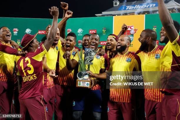 West Indies' players celebrate with the official trophy during a ceremony at the end of the third T20 international cricket match between South...