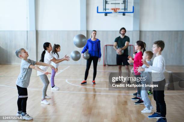 group of pupils with teachers exercising indoors in gym class. - physical education stock pictures, royalty-free photos & images