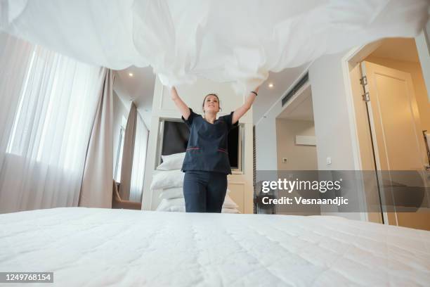 maid doing the bed at hotel room - housework stock pictures, royalty-free photos & images